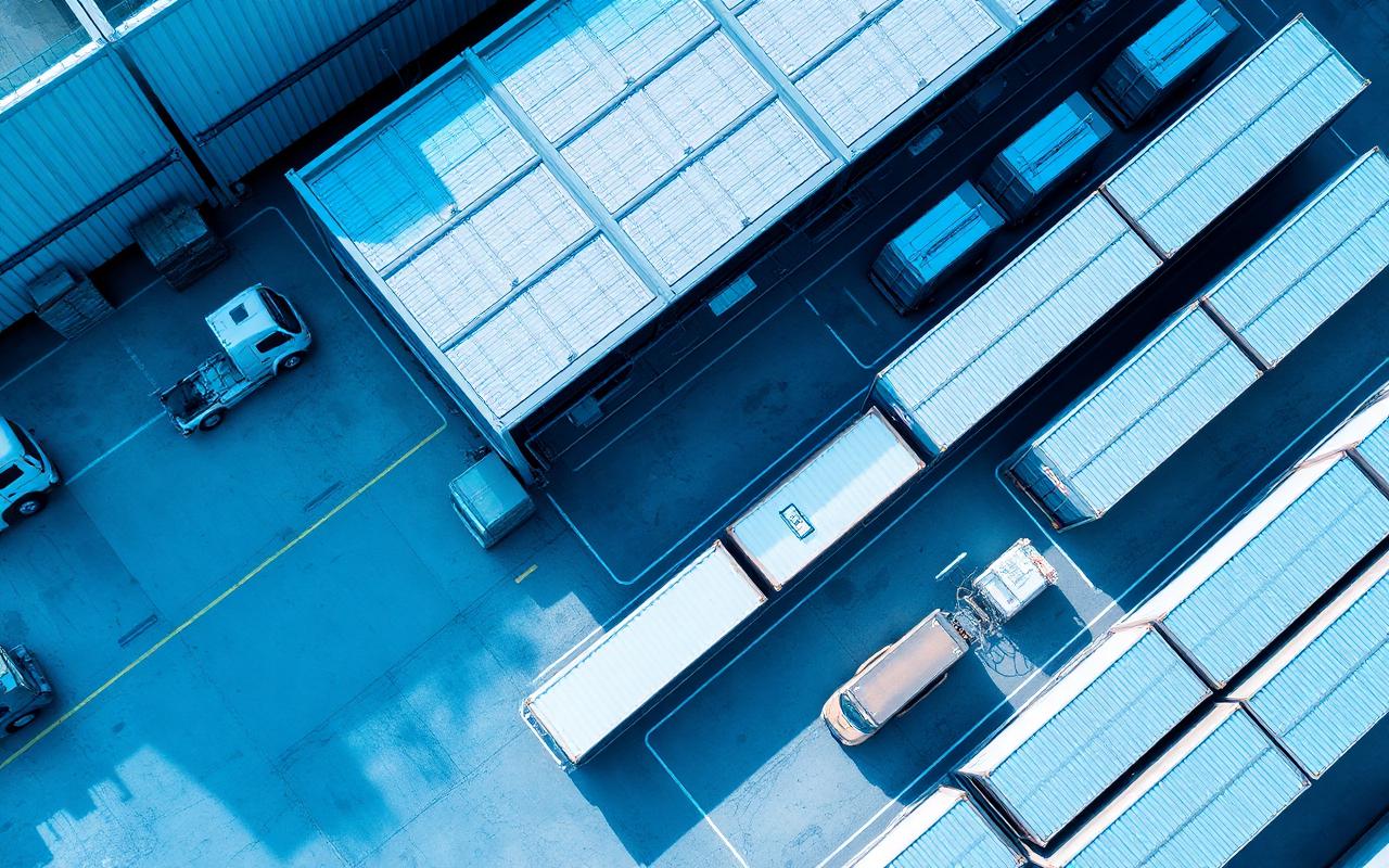 Aerial view of logistics warehouse and cargo trucks